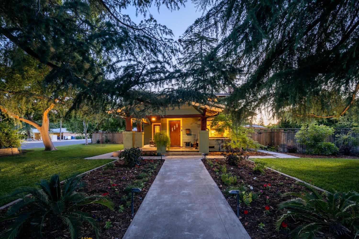 a front view of a house with a yard and garden