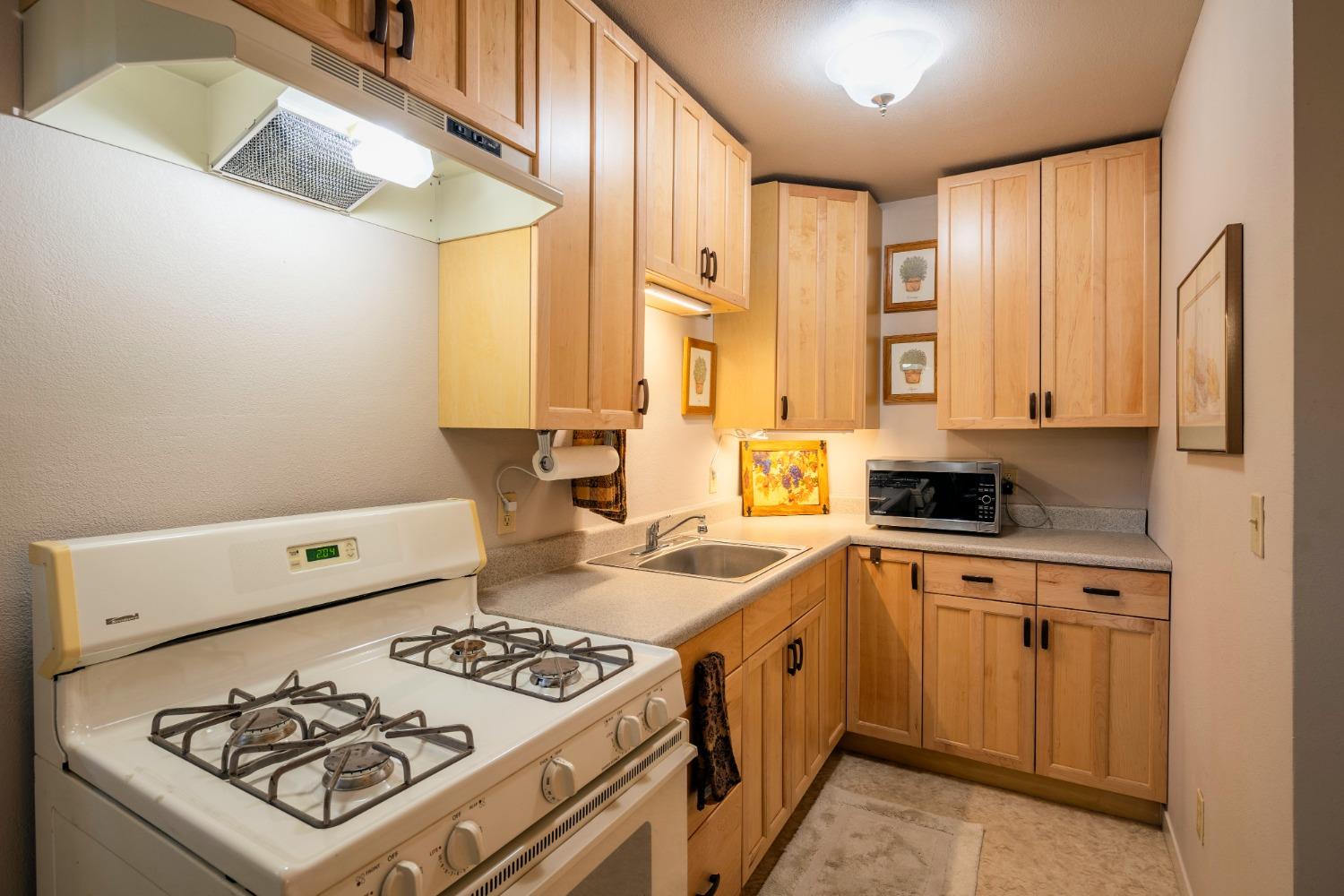 46 Pollasky Avenue Clovis, CA 93612 - Photo 51 of 69 a kitchen with a stove a sink and a refrigerator