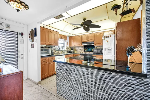 a large kitchen with stainless steel appliances granite countertop a refrigerator and a stove top oven
