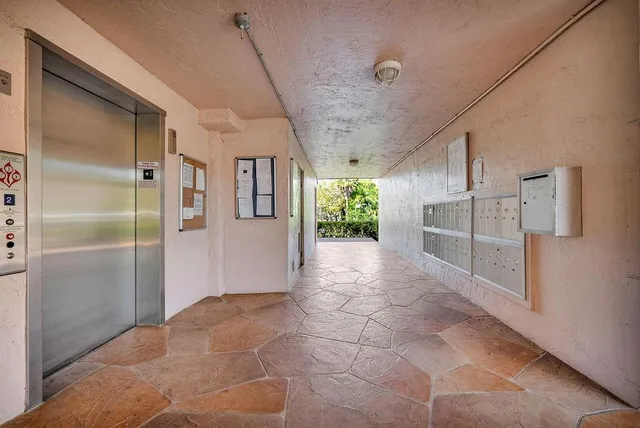 a view of a refrigerator in kitchen and an empty room