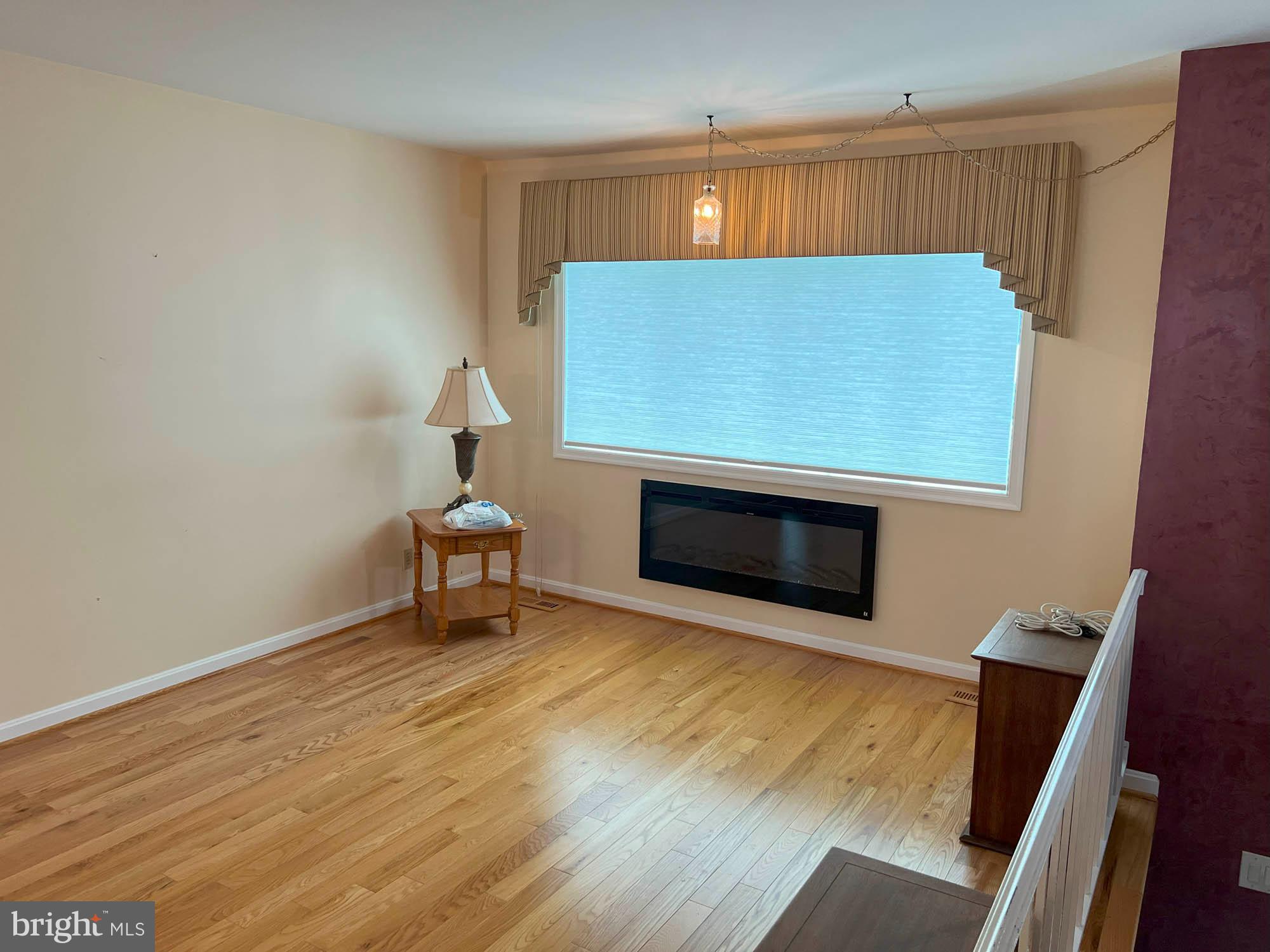 7024 Sollers Point Road Baltimore, MD 21222 - Photo 5 of 22 a living room with a fireplace furniture and a wooden floor