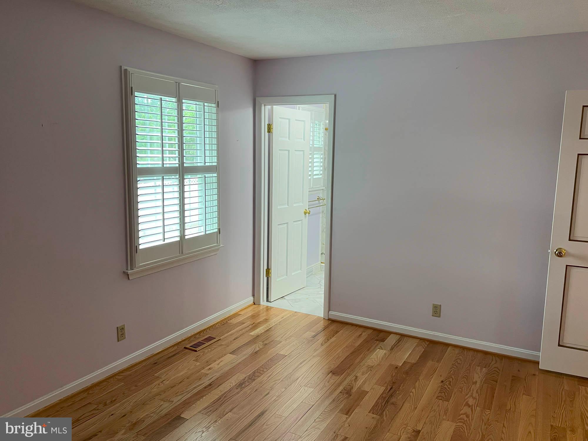 7024 Sollers Point Road Baltimore, MD 21222 - Photo 9 of 22 an empty room with wooden floor and windows