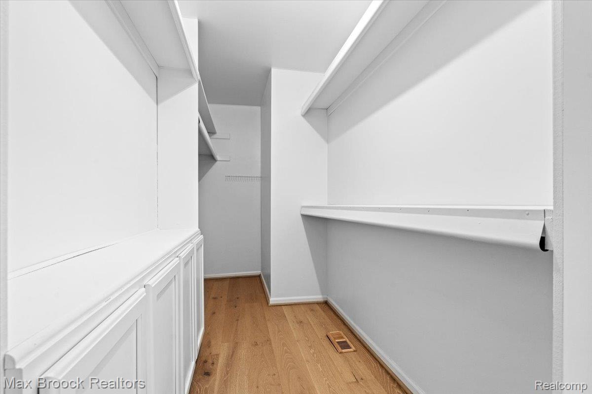 1830 Lone Pine Road Bloomfield Hills, MI 48302 - Photo 52 of 70 Built-in shelving, wood-finish flooring, white panel cabinetry, and white walls