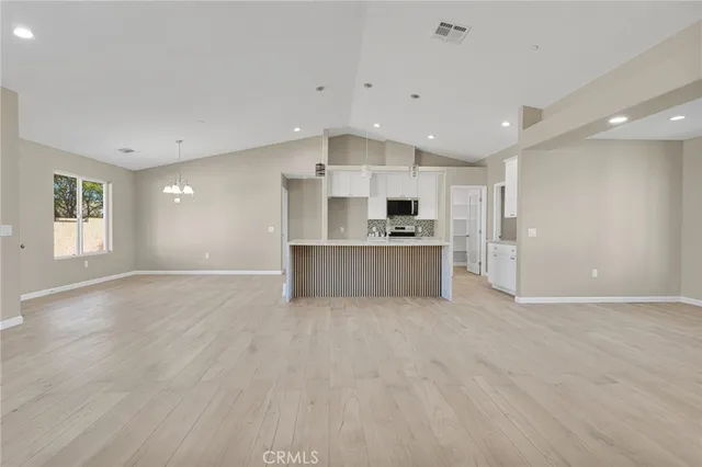 a view of an empty room with a window and a ceiling fan