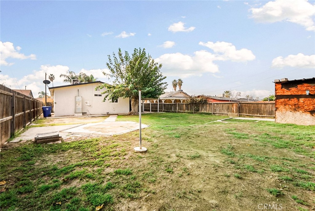 522 Price Street Bakersfield, CA 93307 - Photo 19 of 23 a view of a house with a yard and a garage