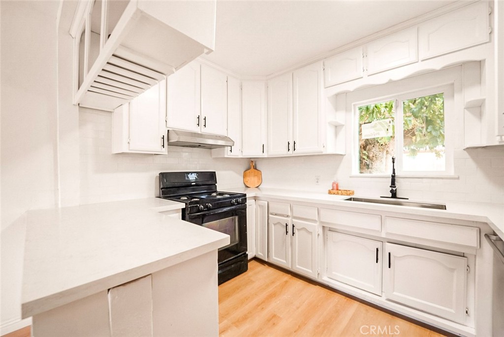 522 Price Street Bakersfield, CA 93307 - Photo 6 of 23 a kitchen with cabinets appliances a sink and a window