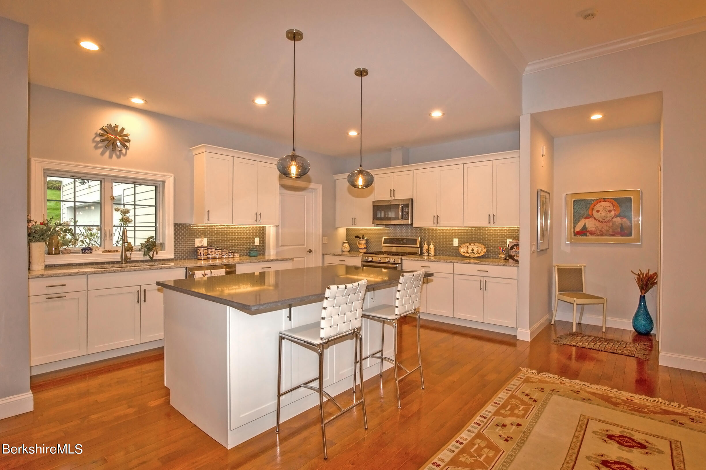 3 Burning Tree Road Great Barrington, MA 01230 - Photo 12 of 50 a kitchen with stainless steel appliances kitchen island granite countertop a stove a sink a refrigerator and white cabinets with wooden floor