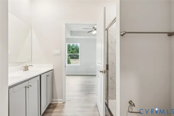 a bathroom with a granite countertop sink a mirror and a shower