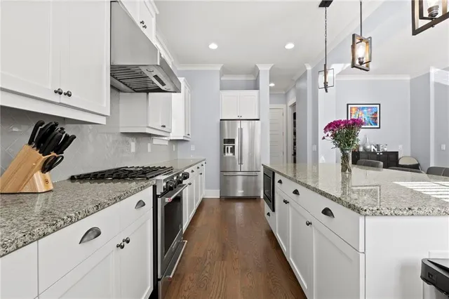 a kitchen with granite countertop a sink stainless steel appliances and cabinets