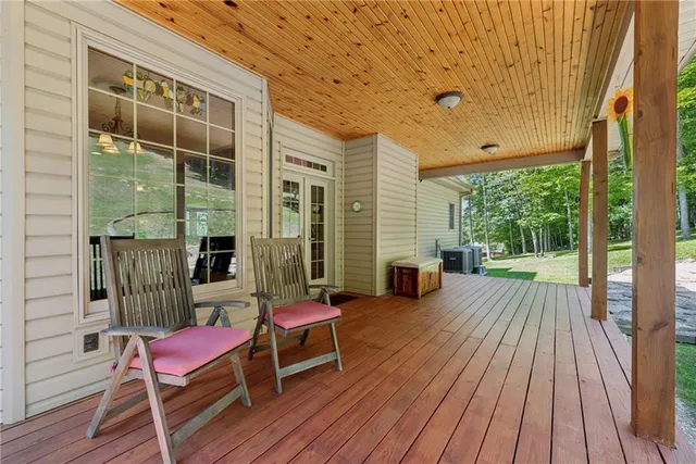 a balcony with wooden floor table and chairs