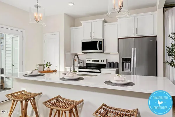 a kitchen with stainless steel appliances a dining table and chairs