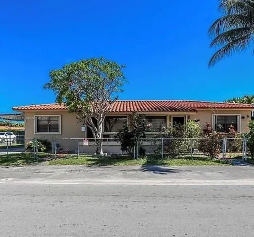 a front view of a house with a tree