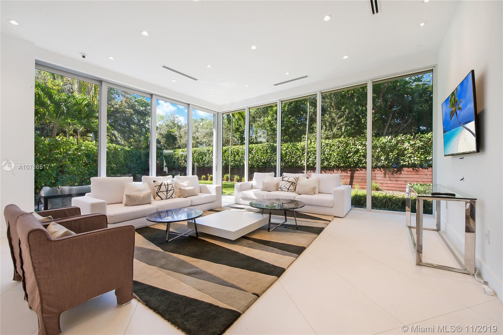 4080 Ensenada Avenue Miami, FL 33133 - Photo 1 of 20 a living room with furniture large windows and a flat screen tv