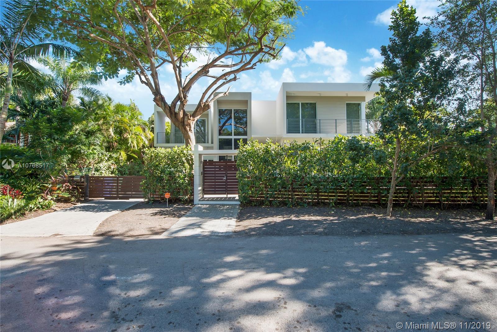 4080 Ensenada Avenue Miami, FL 33133 - Photo 17 of 20 a view of a house with a yard and garage