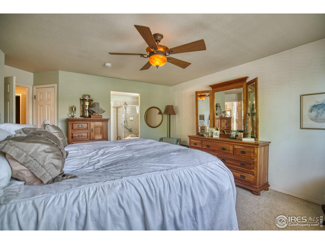 6727 Thistle Ridge Avenue Firestone, CO 80504 - Photo 16 of 40 a bedroom with a bed and dresser with mirror