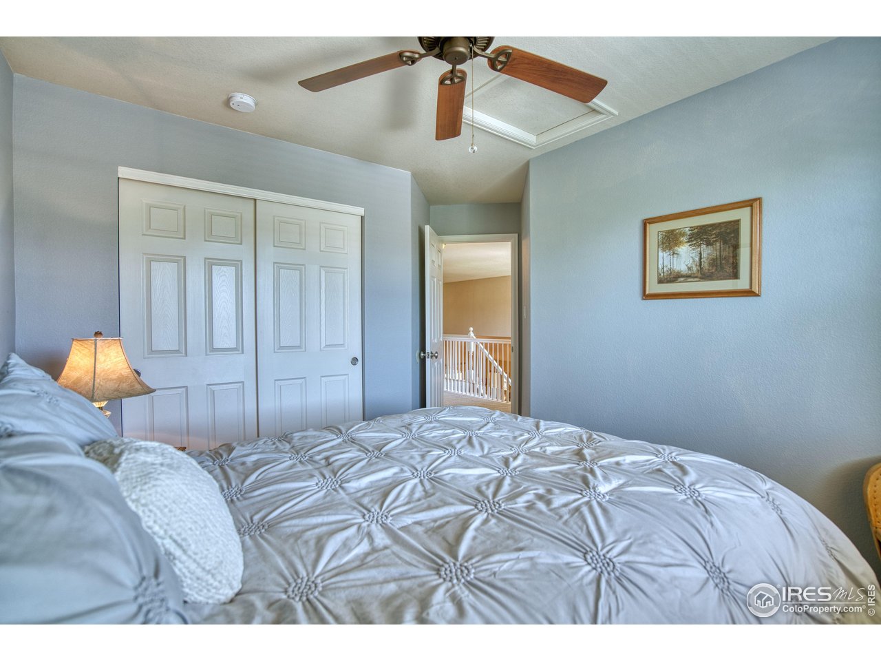 6727 Thistle Ridge Avenue Firestone, CO 80504 - Photo 26 of 40 a bedroom with a bed and a lamp on dresser
