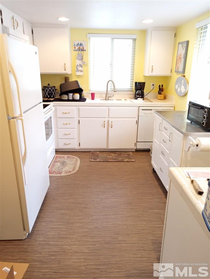 3422 Bowie Road Reno, NV 89503 - Photo 4 of 13 a kitchen with granite countertop a sink a refrigerator a stove a washer and dryer