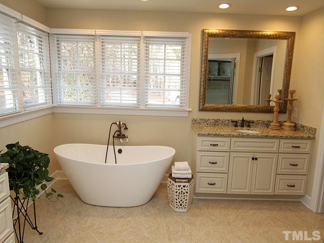 8036 Hawkshead Road Wake Forest, NC 27587 - Photo 17 of 25 Beautiful free-standing, deep tub. Twin custom cabinets offer two under-mounted sinks, granite countertops, and bronze faucets. Custom tile shower with frameless glass enclosure is in adjoining room. Master Closet includes well-designed shelves and rods.