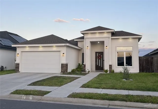 a front view of a house with a yard and garage