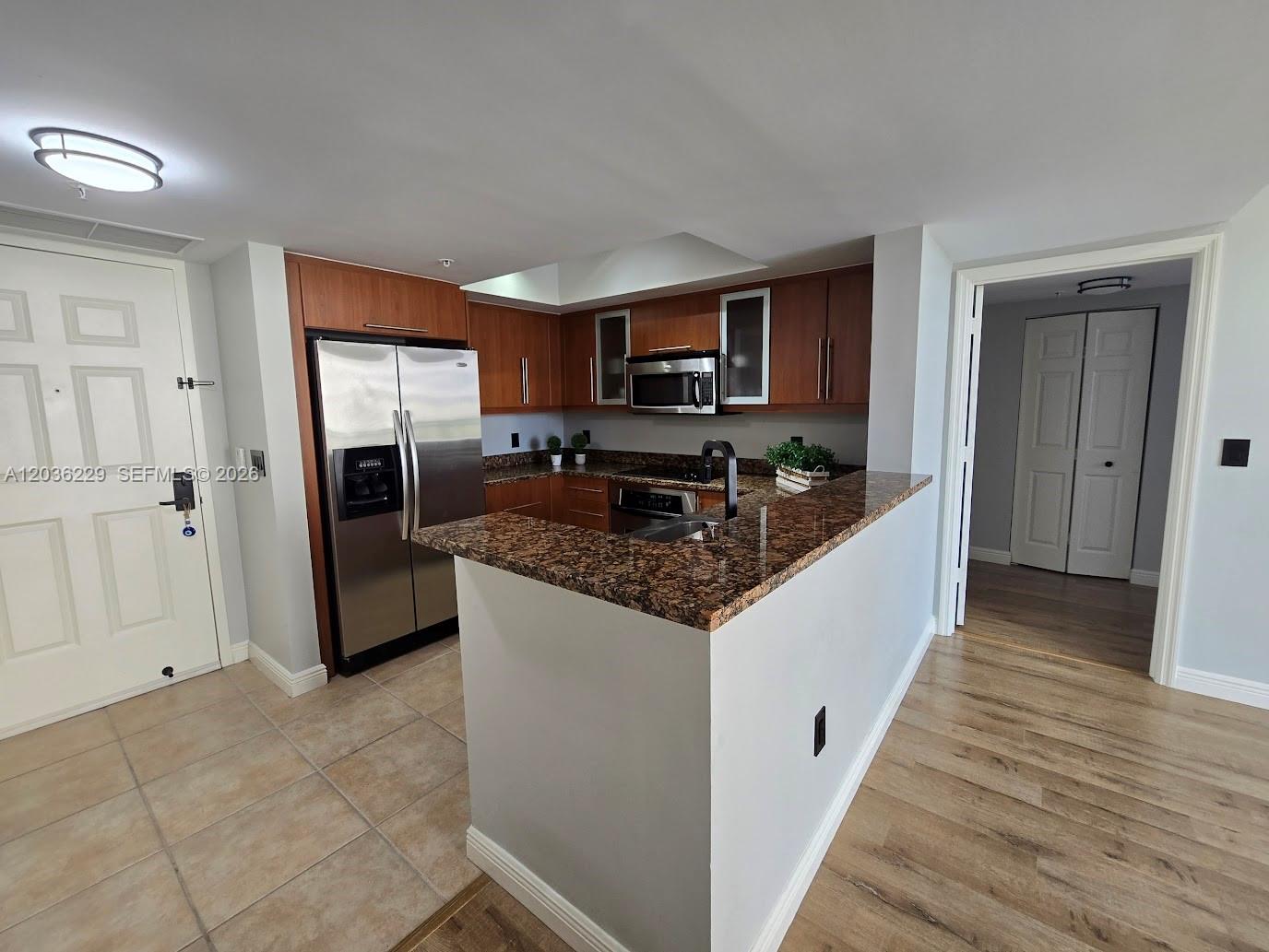 888 Douglas Road, Unit 605 Coral Gables, FL 33134 - Photo 5 of 21 a kitchen with stainless steel appliances granite countertop a refrigerator and a sink