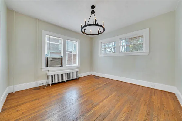 a view of an empty room with wooden floor window and wooden floor