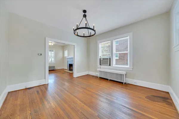 a view of empty room with wooden floor and window