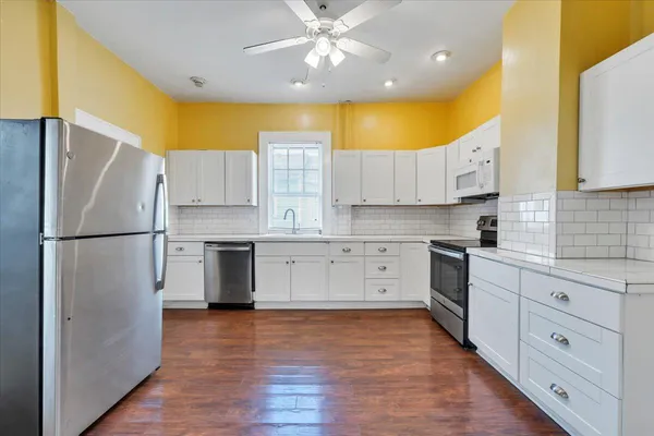 a kitchen with stainless steel appliances a refrigerator sink and cabinets