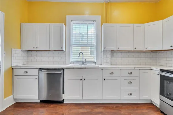 a kitchen with white cabinets and a stove