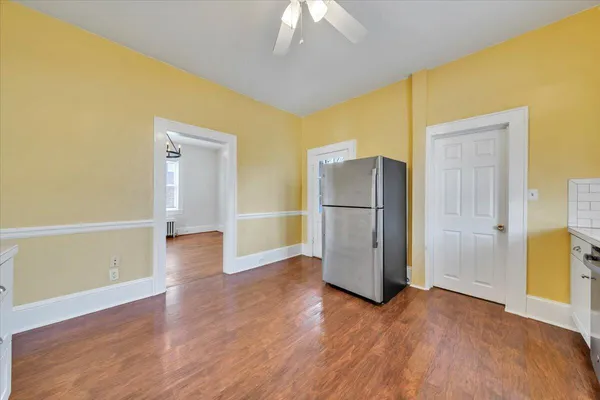a kitchen with a refrigerator and a wooden floor