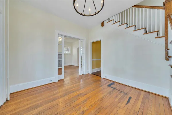 a view of a room with wooden floor and a ceiling fan