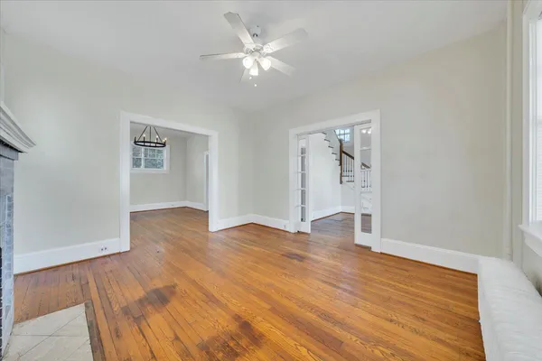 an empty room with wooden floor and ceiling fan