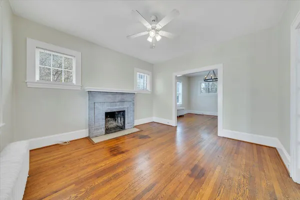 a view of empty room with wooden floor and fireplace