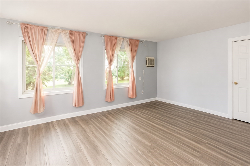 2 Universal Street, Unit 4 Framingham, MA 01702 - Photo 4 of 18 a view of an empty room with wooden floor and a window