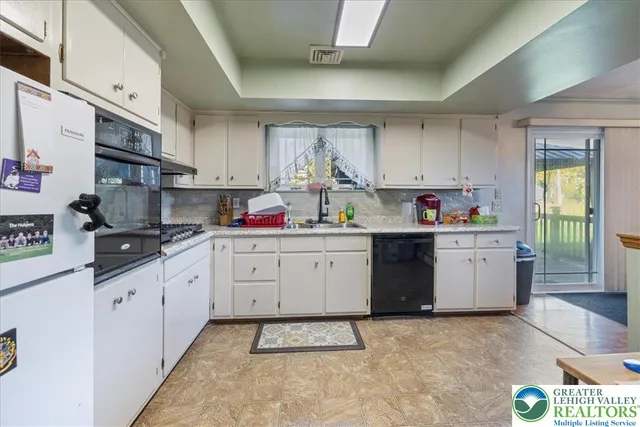 a kitchen with white cabinets and white appliances