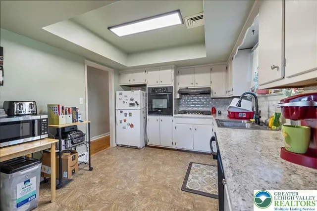 a dining room with furniture a chandelier and wooden floor