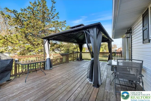 a view of a roof deck with table and chairs under an umbrella with wooden floor