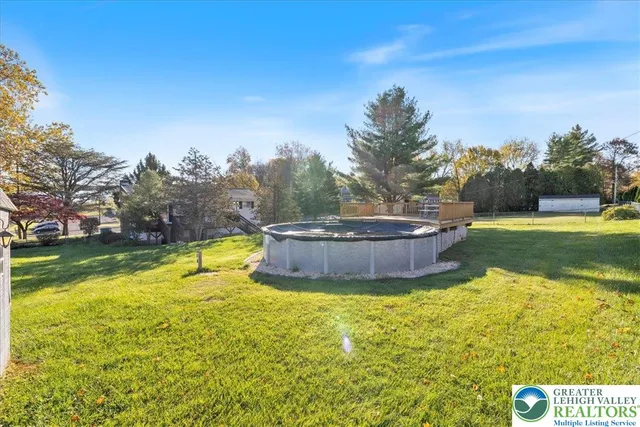 a view of a house with a big yard and large trees