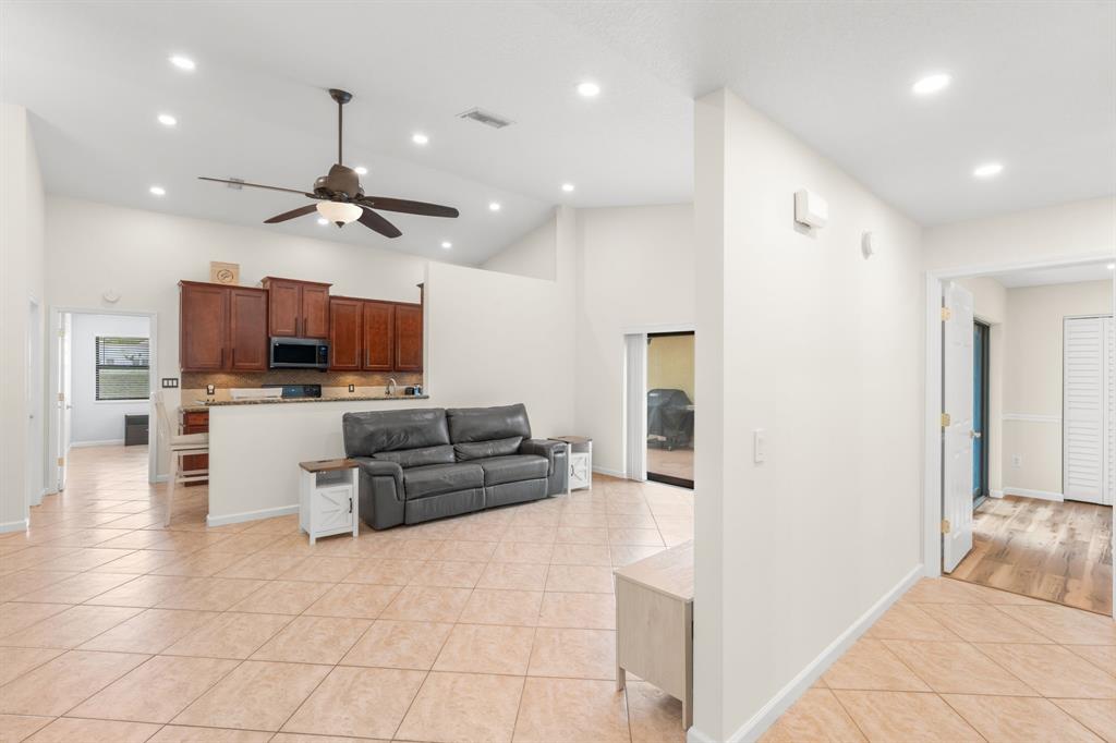 9106 Southwest 22nd Street, Unit D Boca Raton, FL 33428 - Photo 12 of 41 a kitchen with kitchen island granite countertop a refrigerator and a stove top oven