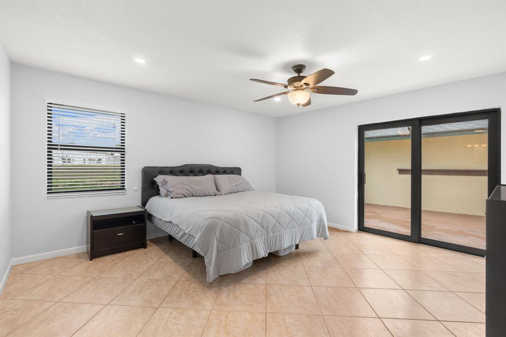 9106 Southwest 22nd Street, Unit D Boca Raton, FL 33428 - Photo 16 of 41 a spacious bedroom with a bed and a table