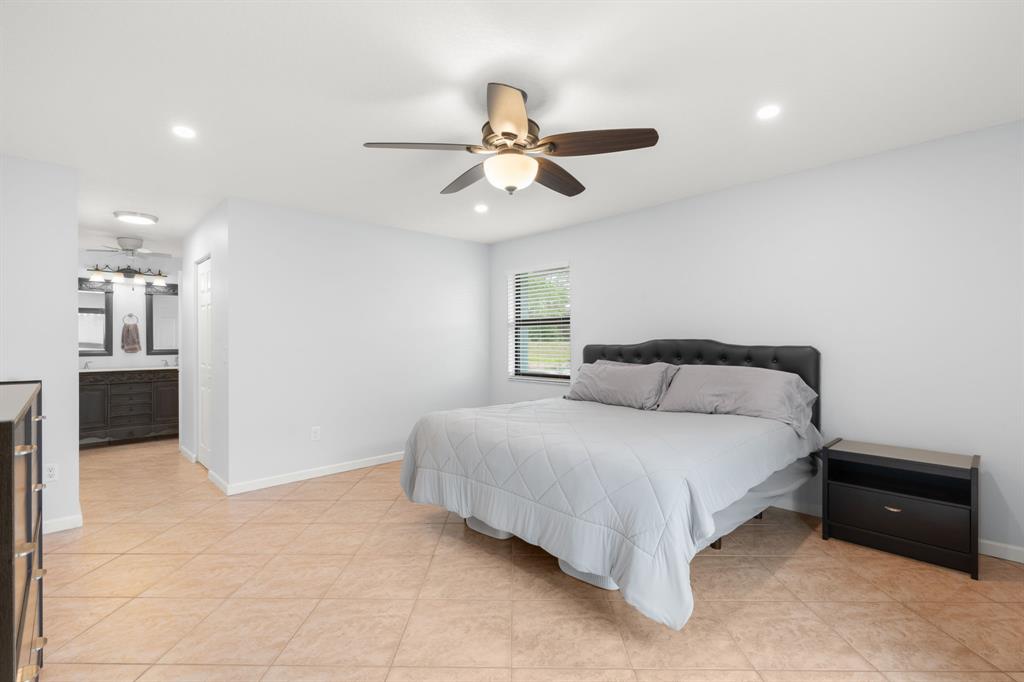 9106 Southwest 22nd Street, Unit D Boca Raton, FL 33428 - Photo 17 of 41 a bedroom with a bed and a chandelier