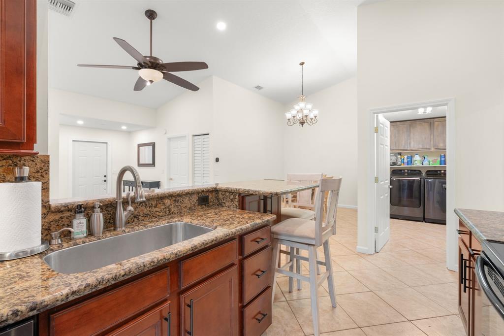 9106 Southwest 22nd Street, Unit D Boca Raton, FL 33428 - Photo 7 of 41 a kitchen with granite countertop a sink a counter top space appliances and cabinets