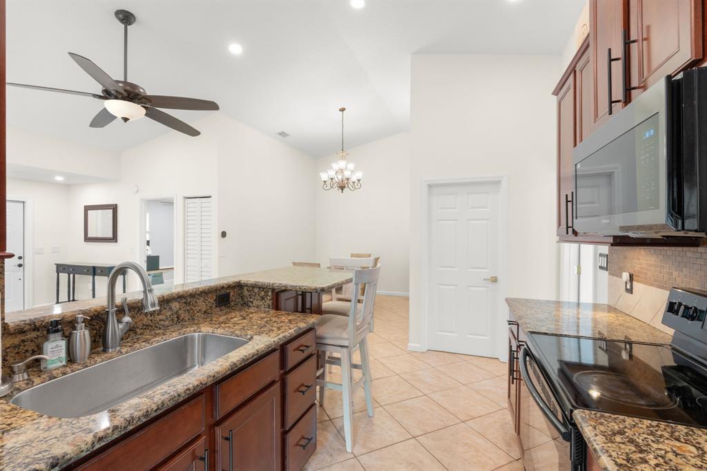9106 Southwest 22nd Street, Unit D Boca Raton, FL 33428 - Photo 8 of 41 a kitchen with stainless steel appliances granite countertop a sink and a stove
