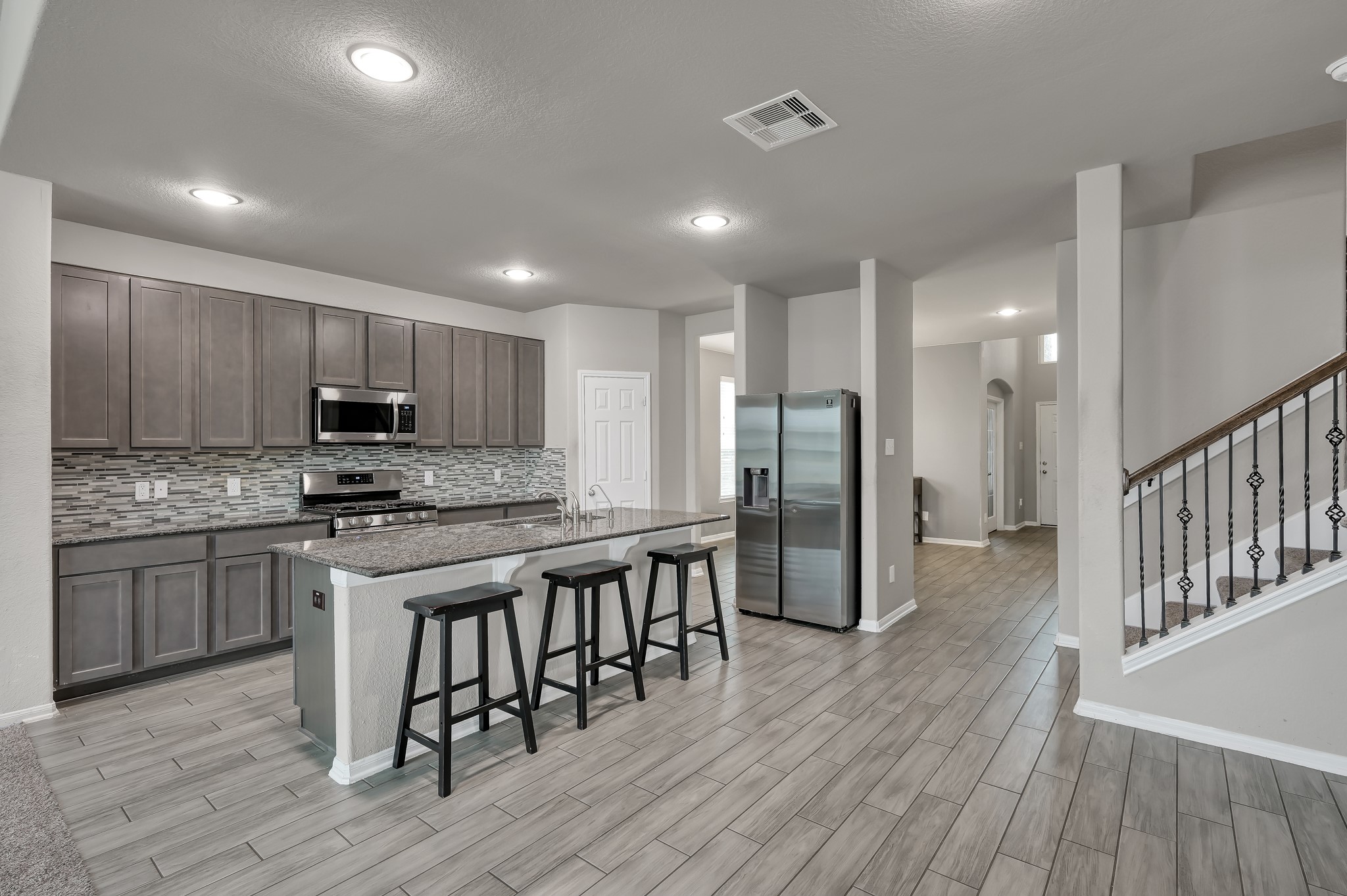 29211 Sequoia Tree Trail Spring, TX 77386 - Photo 6 of 32 a kitchen with stainless steel appliances granite countertop wooden floors a stove and a refrigerator