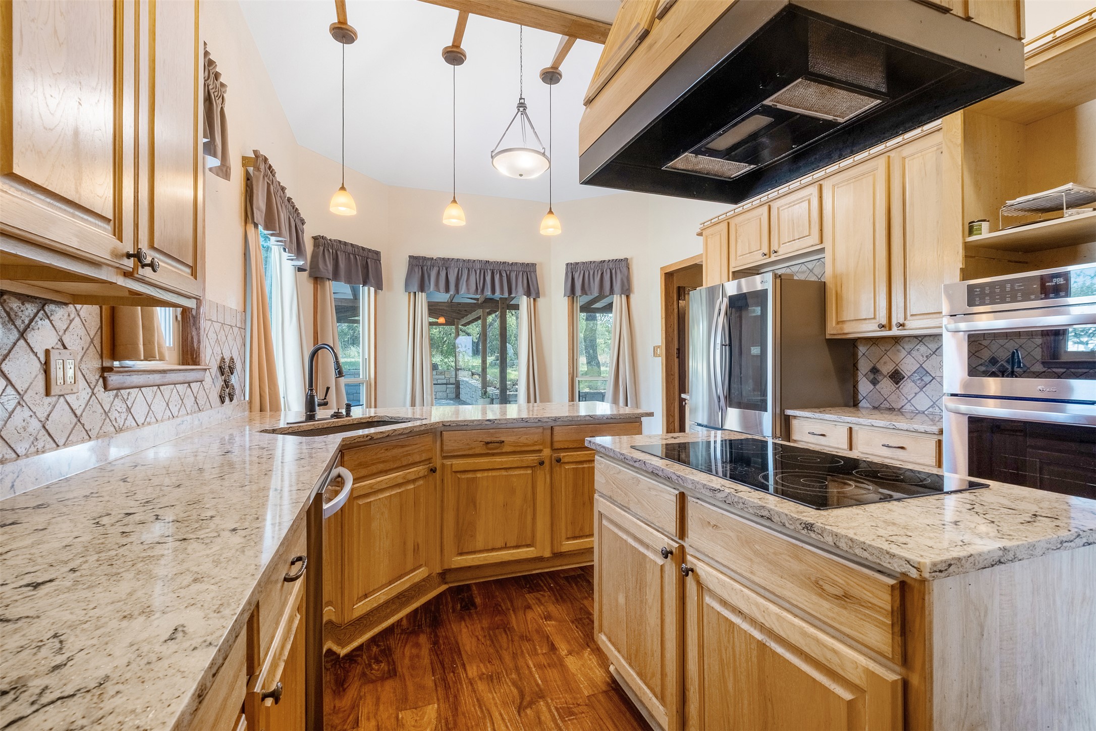 360 Sunset Ridge Drive Liberty Hill, TX 78642 - Photo 14 of 40 a kitchen with stainless steel appliances granite countertop a sink and wooden floors
