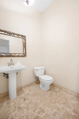 a bathroom with a toilet sink and mirror