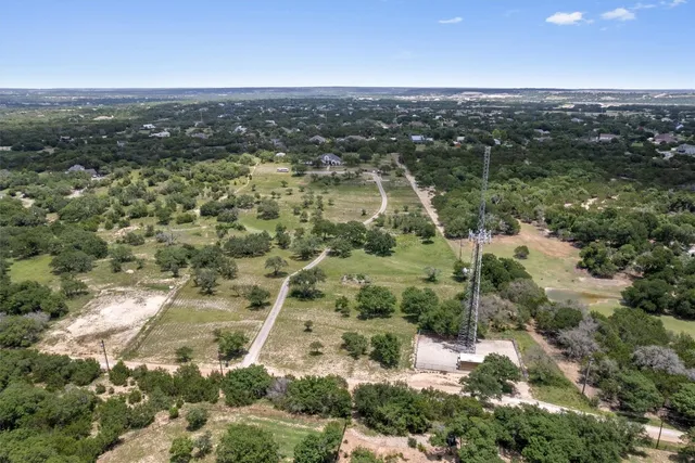 an aerial view of residential houses with outdoor space and trees