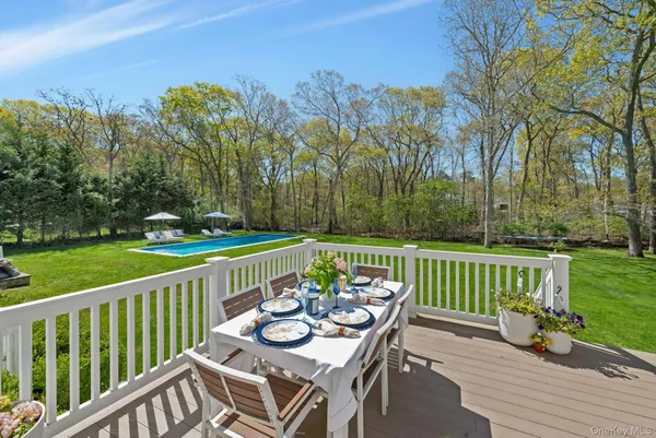 a view of a deck with furniture and trees in the background