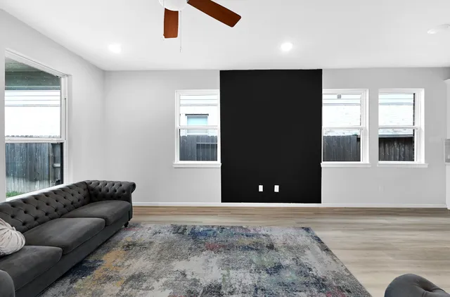 a view of a livingroom with a ceiling fan and windows