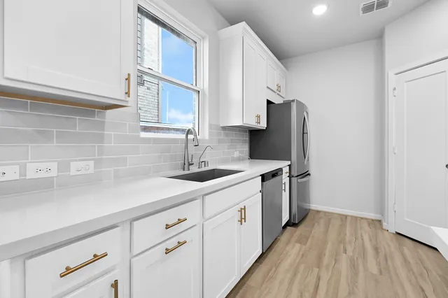 a kitchen with stainless steel appliances granite countertop a sink stove and refrigerator