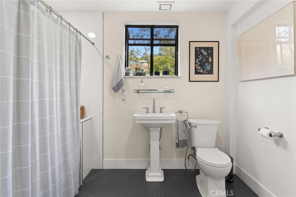 645 Griffith Way Laguna Beach, CA 92651 - Photo 23 of 46 a bathroom with a toilet a sink and a window
